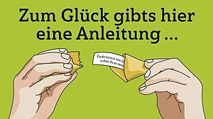 Zwei Hände öffnen einen Glückskeks