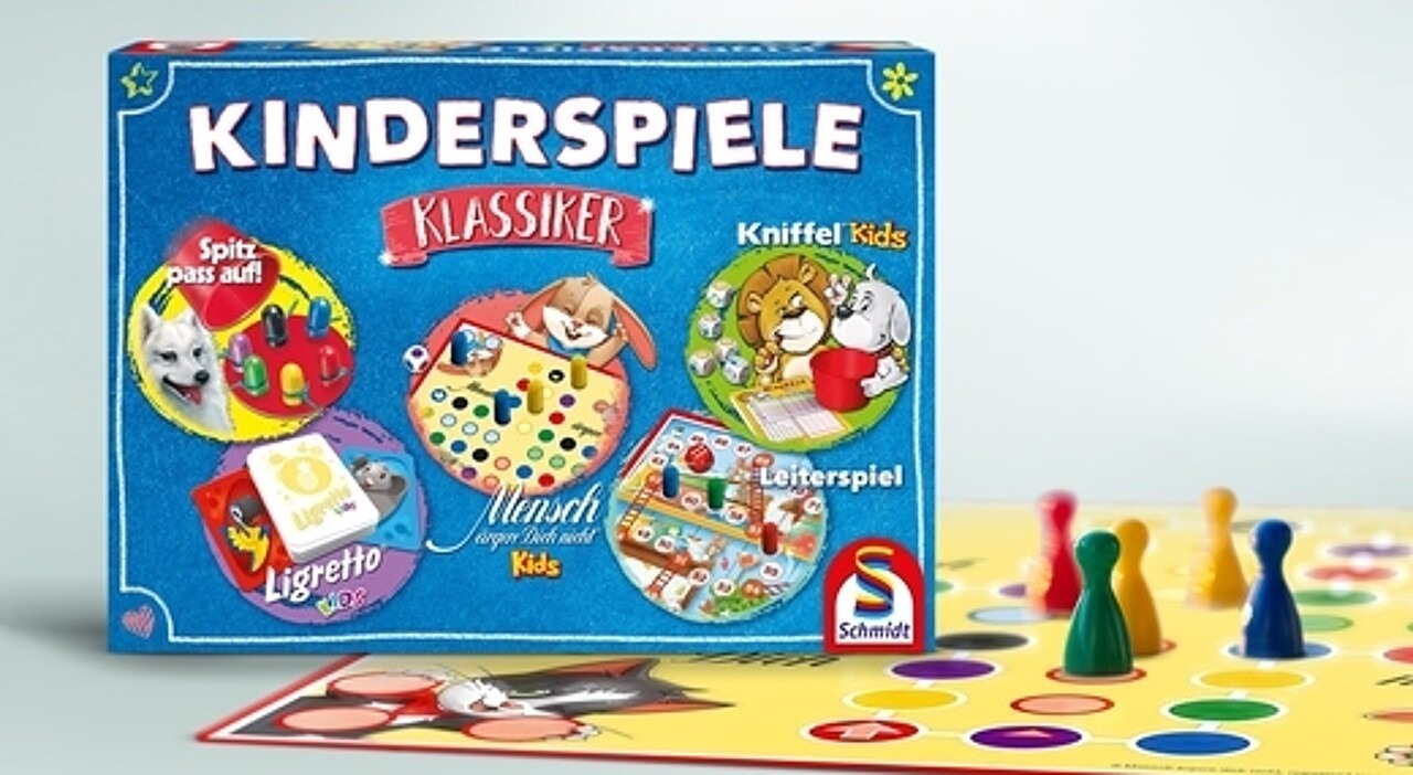 Abgebildet ist die Kinderspiele-Sammlung zusammem mit einem Spielbrett von „Mensch ärgere Dich nicht“ und den dazugehörigen Spielfiguren.