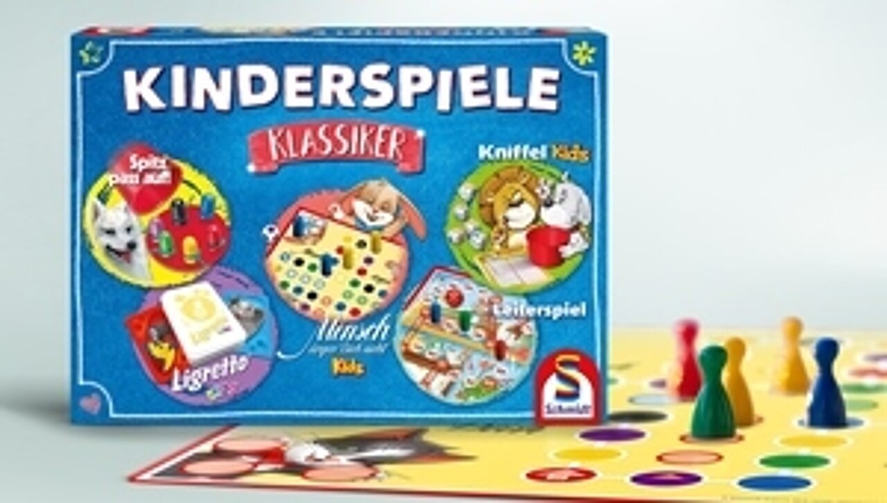 Abgebildet ist die Kinderspiele-Sammlung zusammem mit einem Spielbrett von „Mensch ärgere Dich nicht“ und den dazugehörigen Spielfiguren.