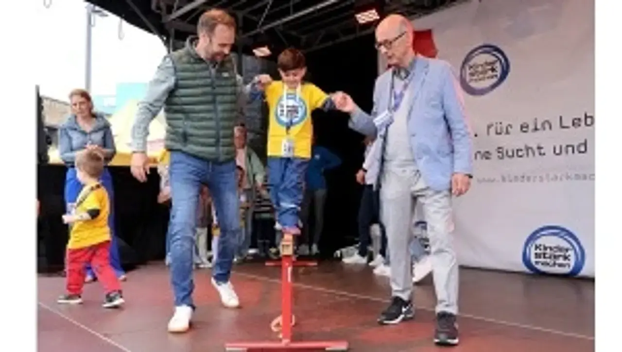 © Carsten Kobow Robert Voigtsberger und Dr. Johannes Nießen reichen einem Jungen beim Balancieren eine helfende Hand.