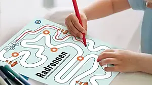 © Ina Kerckhoff Ansicht der Spielvorlage mit Hand, die mit einem Stift die vorgegebene Strecke „abfährt".
