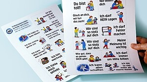 Bild von zwei Papierbögen mit illustrierten Bindungsbotschaften, die Kinder stark machen.